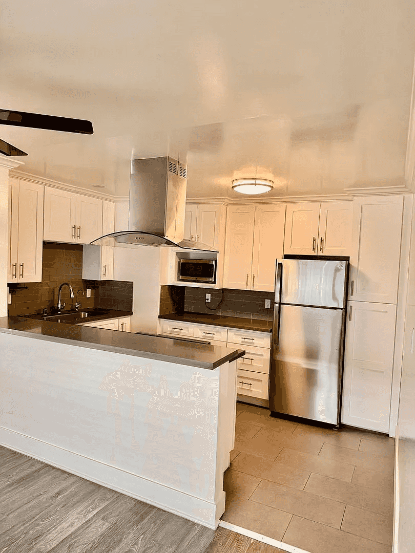 renovated kitchen with quartz counters and white shaker cabinets