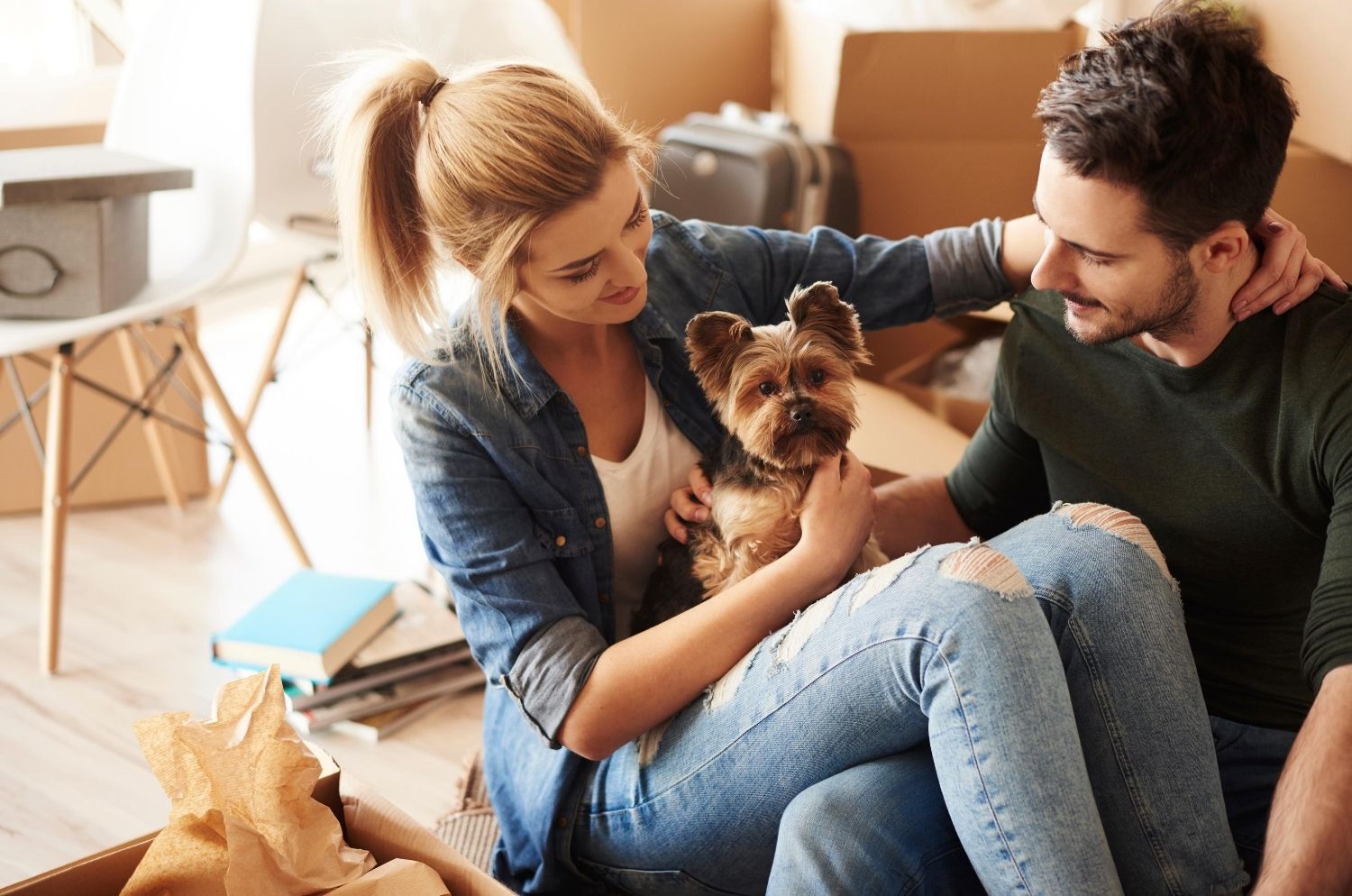 Happy couple unpacking from move, with their pet dog